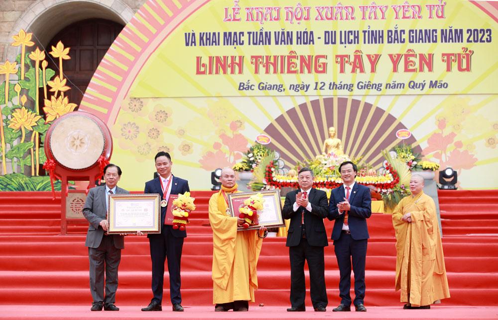 Đồng chí Trương Quang Hải, Giám đốc Sở Văn hóa, Thể thao và Du lịch (thứ hai từ trái sang) và lãnh đạo Hội Phật giáo tỉnh nhận Kỷ niệm chương và Bằng xác nhận kỷ lục gia 